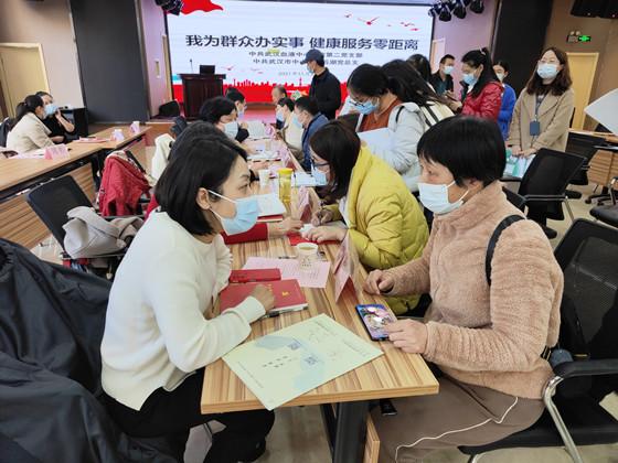 武汉市中心医院临床专家党员团队代表正为献血者张倩进行健康咨询服务